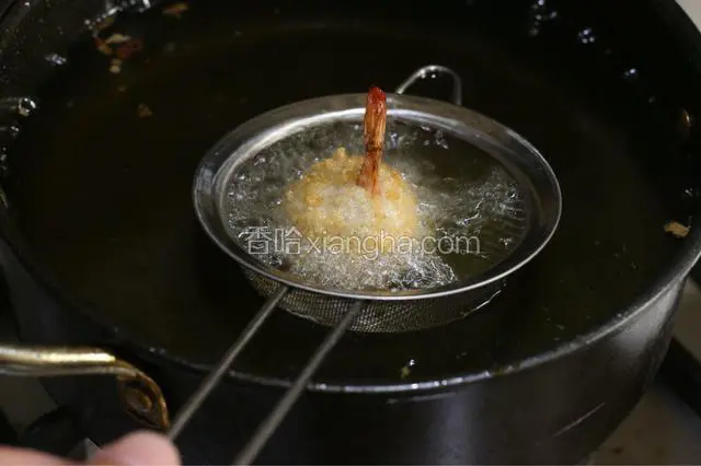 油炸锅倒油烧热，加入裹好粉的虾，中小火炸透至虾球上浮，捞出后猛火再炸一次。表面金黄，捞出控油。