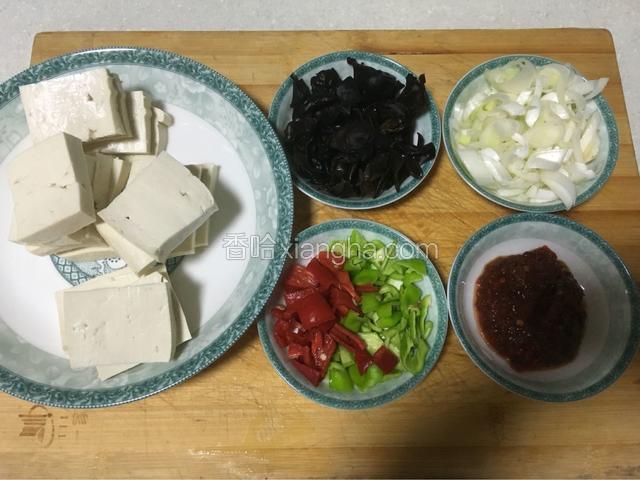 豆腐切成薄片，黑木耳切丁，红、绿辣椒切丁，大葱切薄片，郫县豆瓣酱备好，