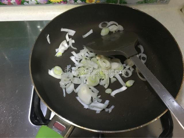 锅内留少许底油，倒入大葱翻炒，