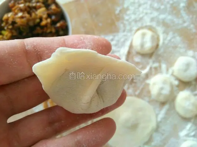 再用两只手的虎口处把饺子皮的边缘捏紧即可，看饺子包好了。