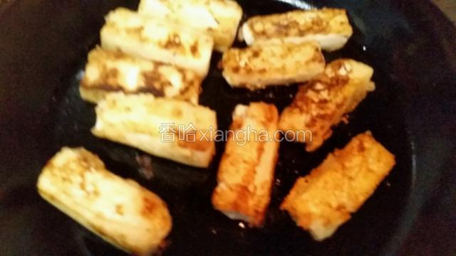 热锅下油，豆腐一边沾生粉一边下，煎至金黄色翻面再全部煎至金黄，盛起备用
