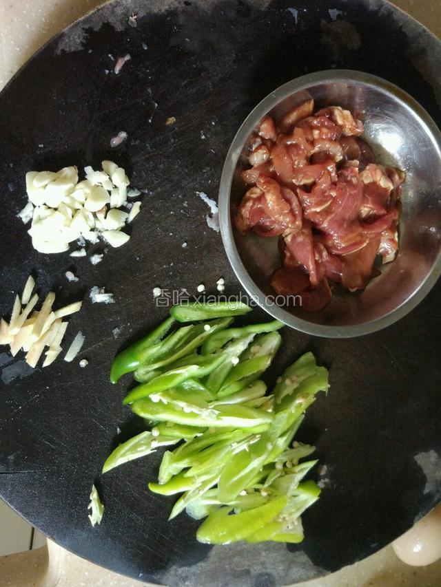 准备下食材，把瘦肉切条，用请适量的生抽，料酒，盐，生粉腌制十五！青辣椒切菱形，姜切丝，大蒜切片，备用！