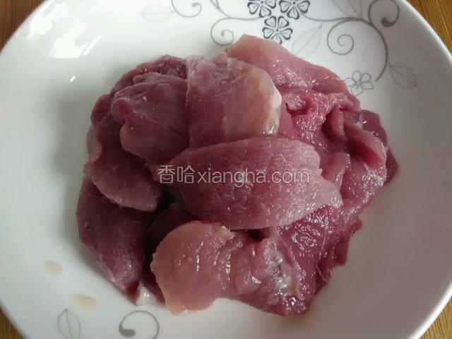 把猪肉切成两指宽长的薄肉片。