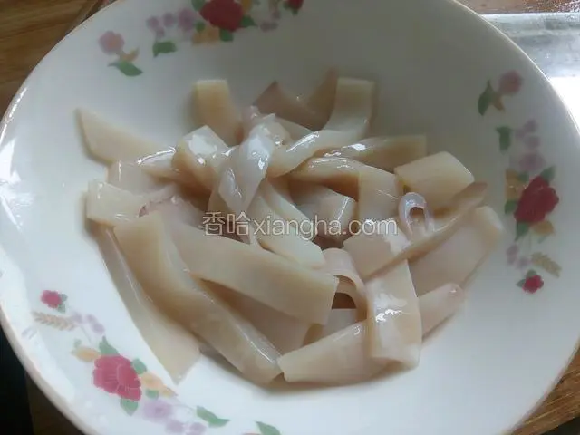 鱿鱼撕去黑衣，洗净在鱼上斜切三分之一深斜口，再切条，用料酒，一点盐，淀粉搅拌均匀腌制10分钟