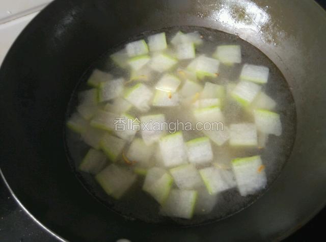 炒至冬瓜断生，加少许料酒，倒入足量水。