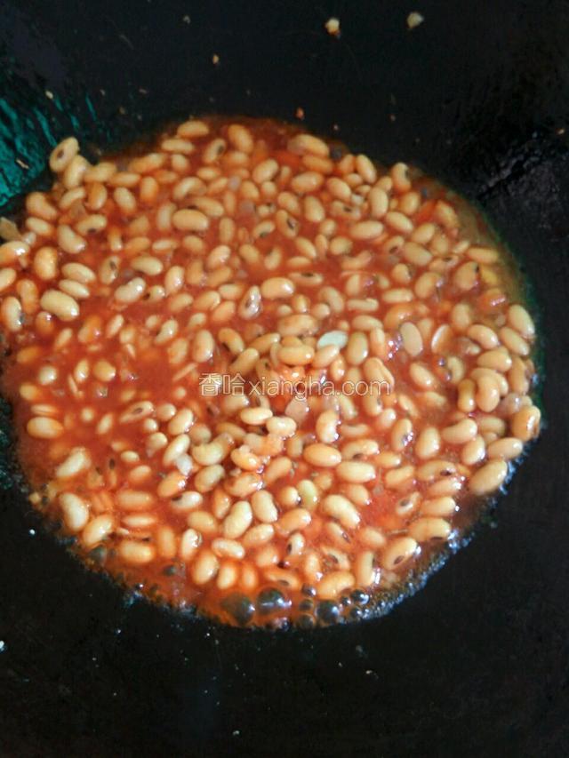 锅中下油烧热，下蒜末炒香，下泡发好的黄豆黄豆翻炒一会，放入调好的茄汁，大火烧开转中小火，盖上盖子焖至汁少即可