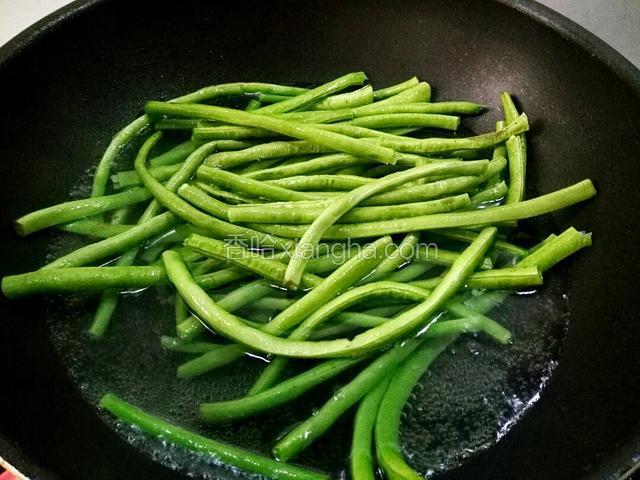 炒锅里添加适量清水，开锅下豆角，焯七分熟。捞出放凉待用。
