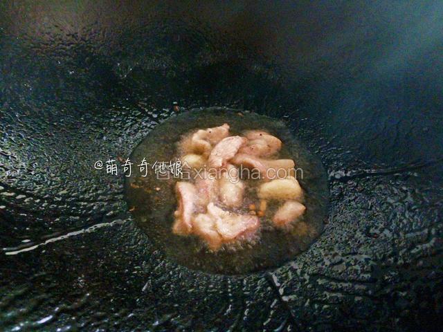 锅中加油烧热下大蒜和猪肉大火炒至微黄。