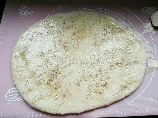 用擀面杖擀成碗边薄厚面皮，放入适量芝麻油抺匀，在撒匀少许盐和椒盐