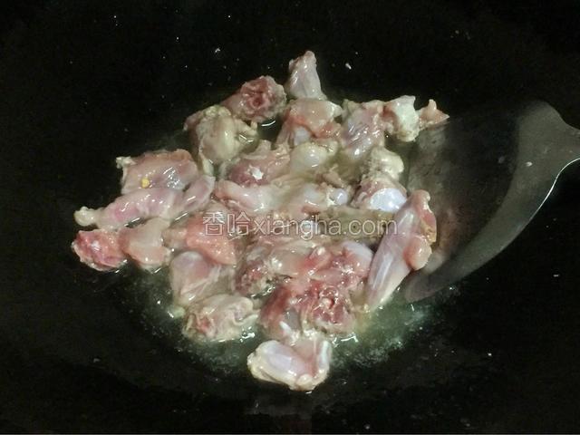 锅里烧油，油要没过兔肉，开大火。油辣了倒入兔肉，炒干水分