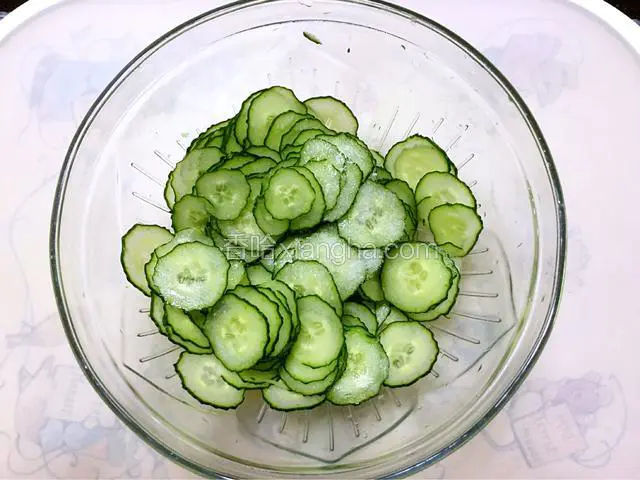 黄瓜洗净切成圆形薄片，用少许盐腌一下。