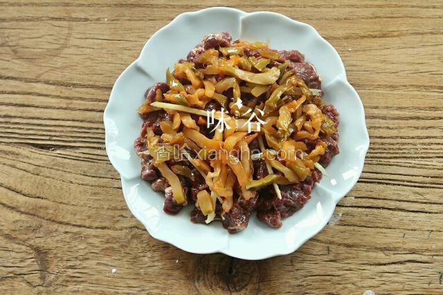 牛肉上面撒上姜丝和榨菜。