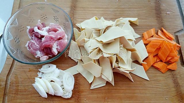 干豆腐和胡萝卜切成斜片，猪肉切薄片，葱切葱花。