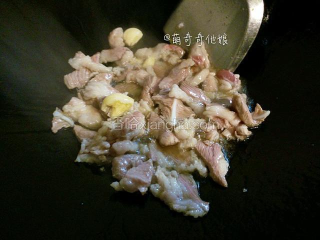 热锅倒油烧热，下猪肉和大蒜大火翻炒至金黄。