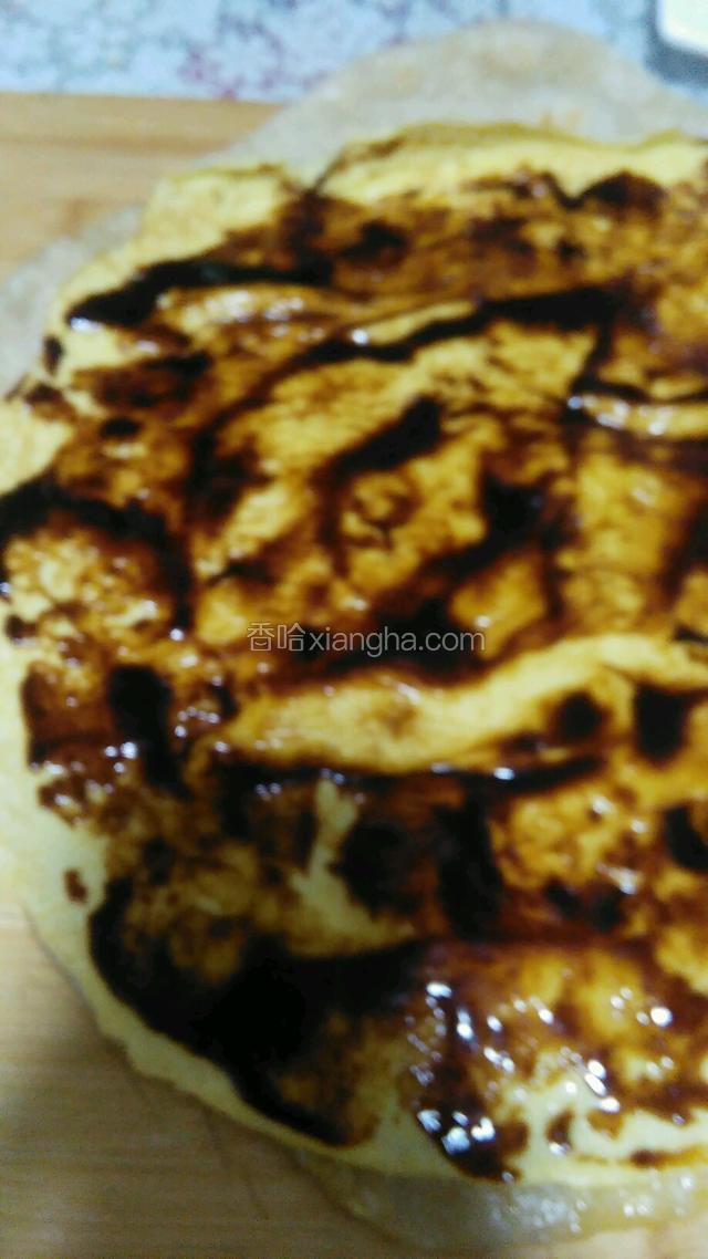 案板上先放面饼，在放鸡蛋饼，在抹一层甜面酱。