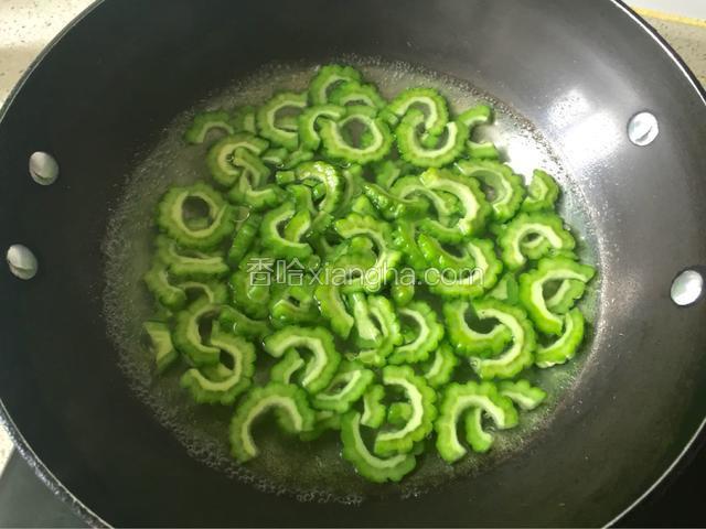 锅里加水烧开，放一勺盐将苦瓜片焯水一分钟。