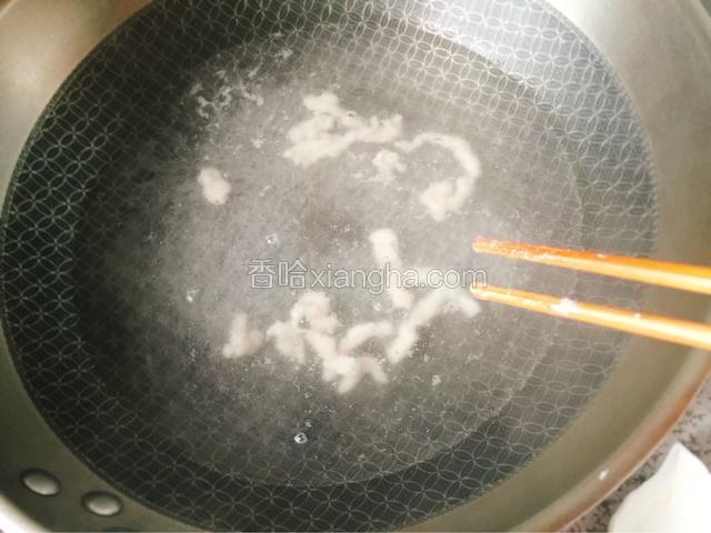 把500克清水放入锅中烧开，这时肉腌制的差不多了，注意这里用筷子夹肉，这样容易定型，一碗都倒下去会结块儿盖上锅盖烧开