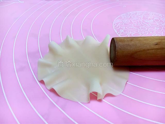 用擀面杖把饺子皮四周擀一圈，让他形成荷叶状。