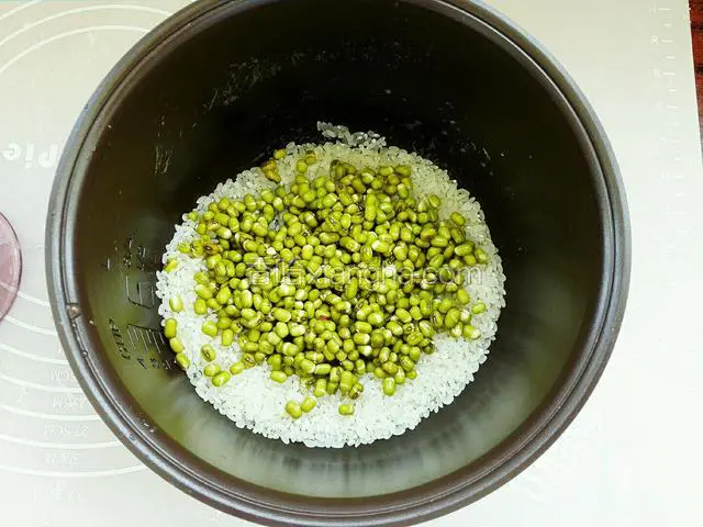 把泡透绿豆捞入大米盆中，然后与大米一同舀洗干净