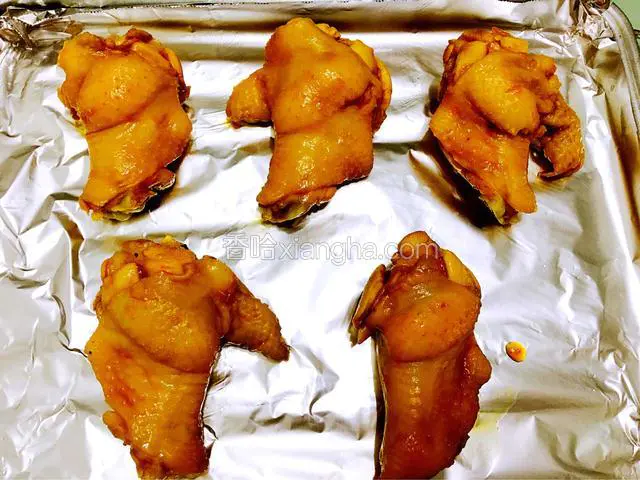 烤箱预热5分钟，190度；把腌好的鸡翅根放在烤盘上，淋上少许腌汁在鸡翅根上。