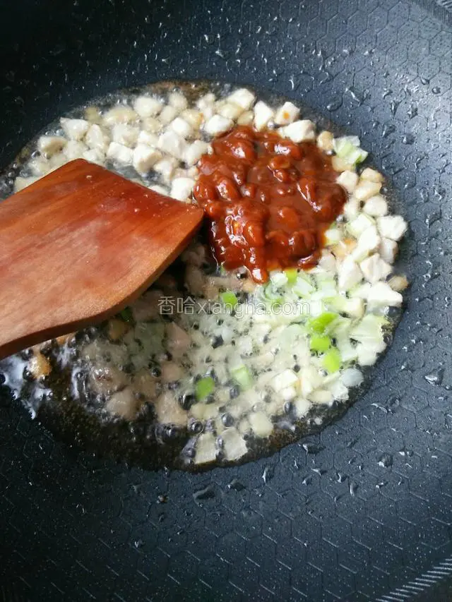翻炒到变色，加入葱姜沫，和一大勺黄豆酱