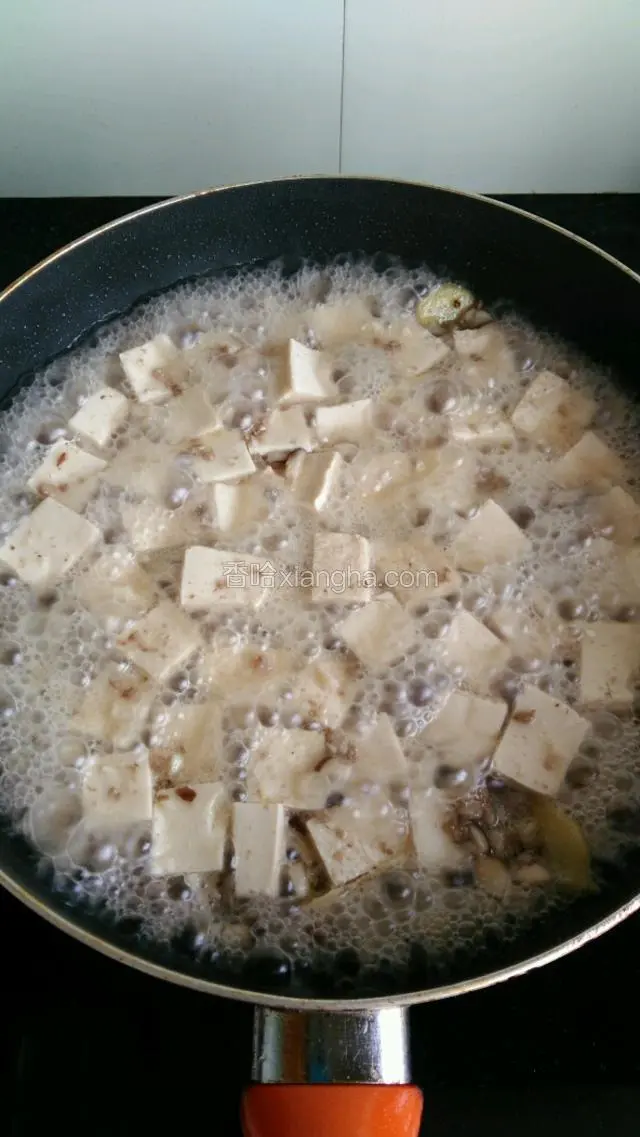 水开后下入切成小块的豆腐， 加盖煮1分钟左右。