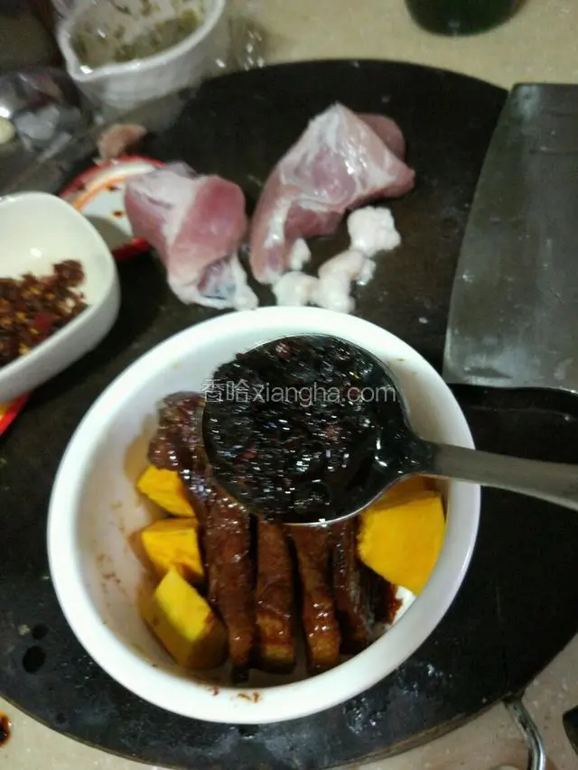 把煮好的腊肉放一个碗里，碗有点大，肉太少了，所以放了点南瓜放入铺顶下！上面放适量的老干妈酱！