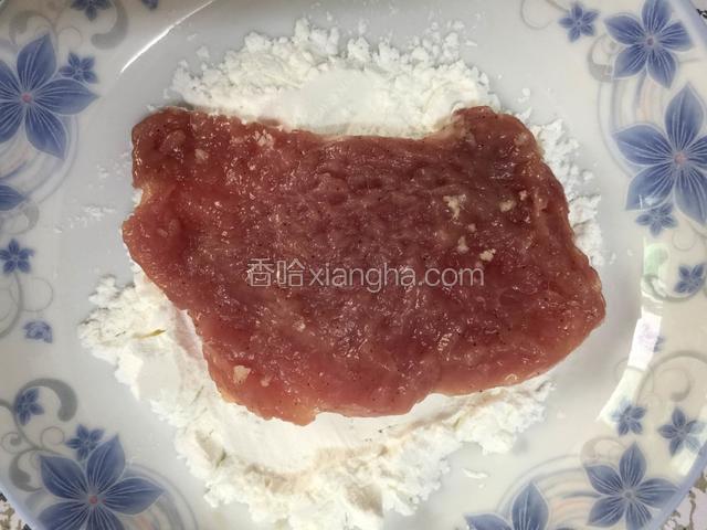 拿起一块肉排先沾淀粉，两面都要沾一下