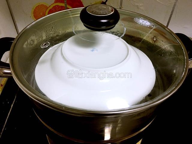 把牛奶碗放入蒸锅中，盖上个盘子，中火蒸10分钟。