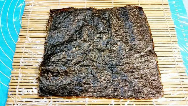 紫菜放在已铺保鲜膜的寿司席上
