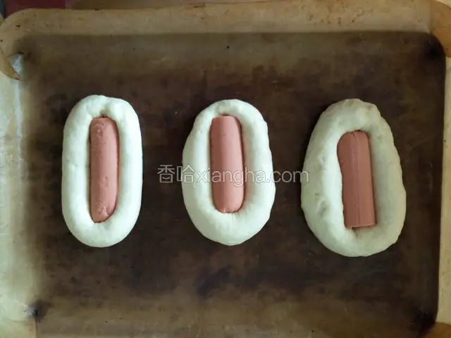 把火腿肠嵌在中间，自然发酵至两倍大