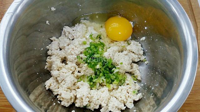 把小葱和豆腐放进容器中打入鸡蛋。