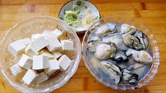 海蛎子洗干净放锅中焯一会接着关火，把海蛎子一个个剥出来，然后总料酒腌制一会！豆腐切块！葱姜末适量！