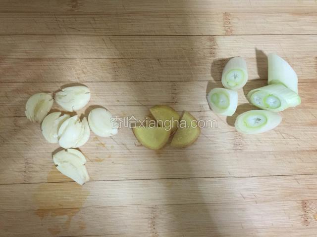 大葱切成段，姜切片，蒜瓣用刀拍碎，备用。