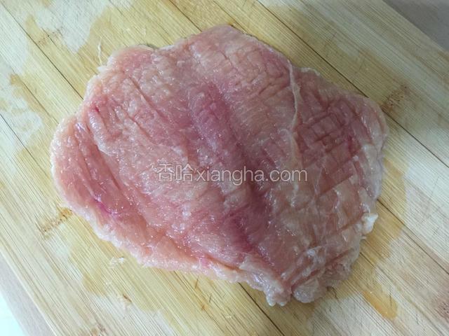 用刀从鸡胸肉中部片开，最后不要切断，打开成一个大片。然后用刀背反复敲打鸡肉，最好二面都敲打一遍。