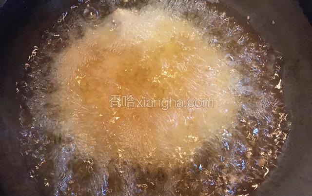 炒锅中倒入宽量食用油，待油温六成热时放入裹好面包糠的鸡胸肉。