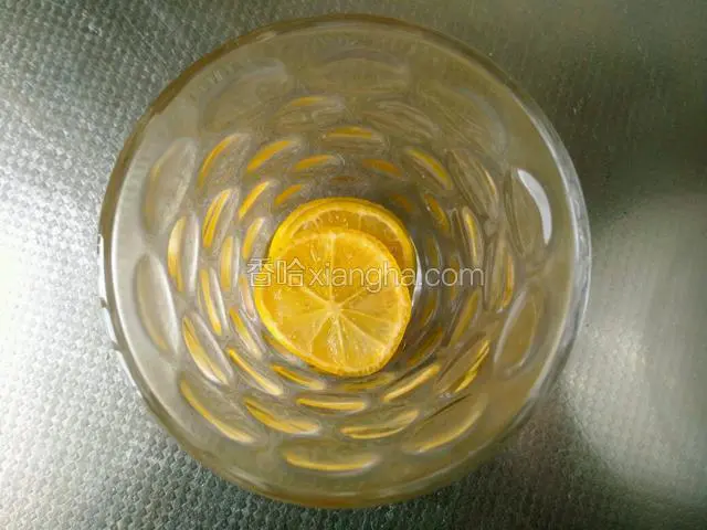 杯子里放两片柠檬，把泡好的兰香子水倒入杯子里