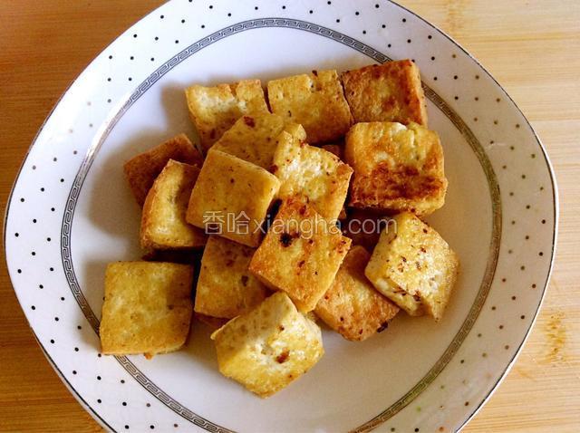 煎好的豆腐放入盘中