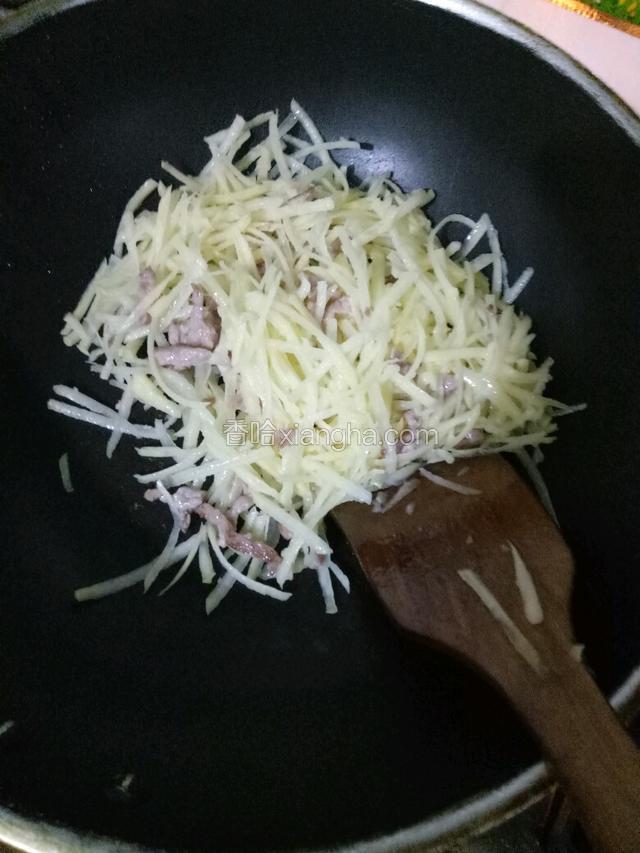 肉丝一转色就加入土豆丝大火翻炒两分钟，要不停的翻锅，防止糊锅。