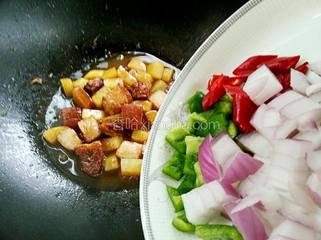 土豆绵软时放入青红椒和洋葱，炒至断生