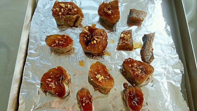 烤盘铺锡纸，把腌制好的鳕鱼块排放烤盘内，上面撒适量的孜然。