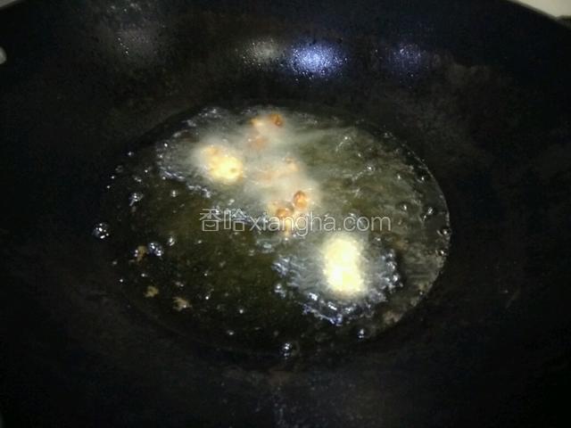 热油锅下滚完面包糠的牡蛎入锅炸，中火，全部炸黄出锅