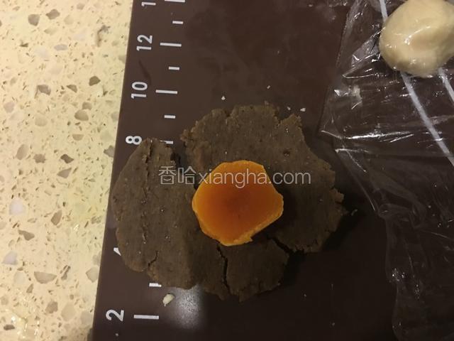 豆沙350g平均分成14份，每份重约25g。取一个豆沙球，包裹住半个放凉的咸蛋黄，团成圆球。