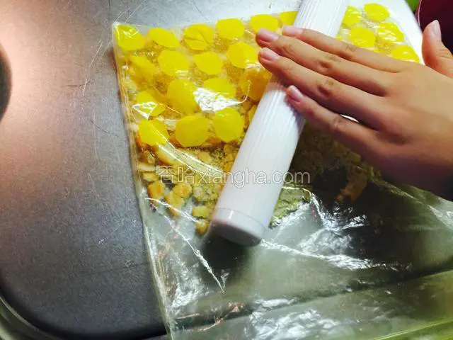 先准备蛋糕底，不用蛋糕底的可以省略这些步骤。把饼干装入塑料袋，用面棍压碎