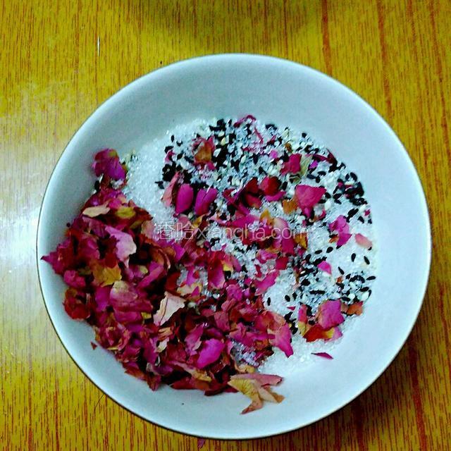 把熟芝麻和白糖加入玫瑰花瓣中
