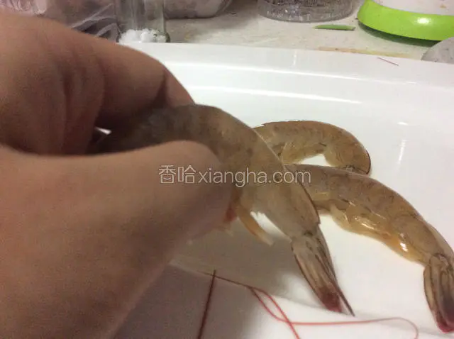 将虾洗净后，拿起一只虾，找到虾尾倒数第二节和第三节之间。