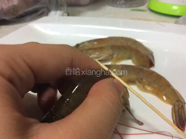 用牙签在这个位置穿过去，先把肉扎散，然后挑起虾线，就能一下子扯出一整根。