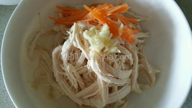 鸡胸肉撕成细丝加入适量胡萝卜丝，蒜末