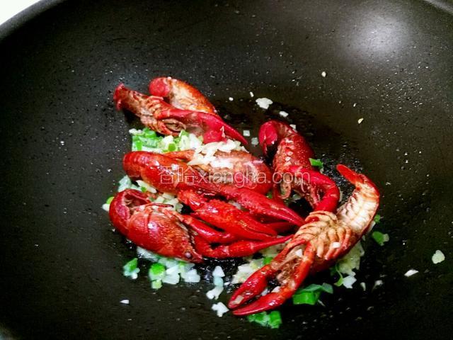 下小龙虾翻炒，倒料酒白酒，醋，盐少许翻炒均匀，