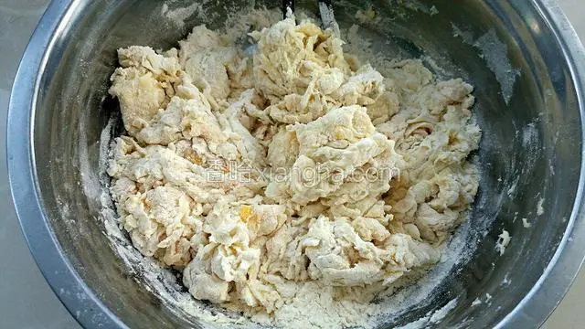 再划圈倒入适量温水，用筷子把面粉搅拌成棉絮状。
